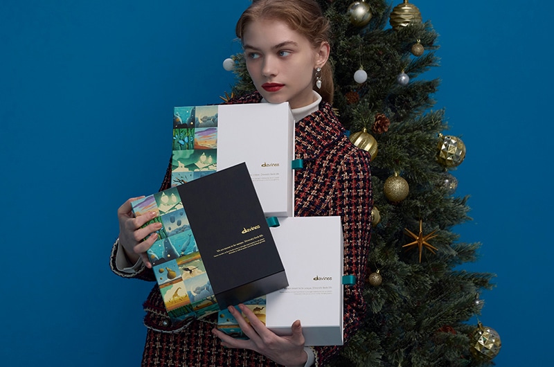 クリスマスツリーとコフレを持つ女性の画像